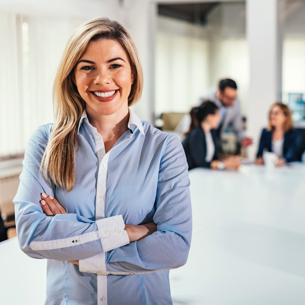 Eine Geschäftsfrau lacht mit verschränkten Armen